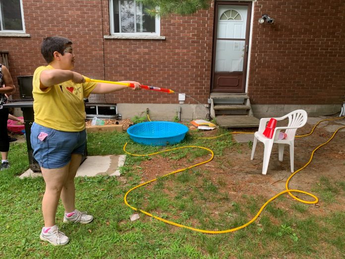 CLSM Photo 5 Community Living South Muskoka: Group home resident Vanessa enjoys games in the garden. She loves water activities, especially when they include water guns and the chance to spray people with them. Photo courtesy of CLSM