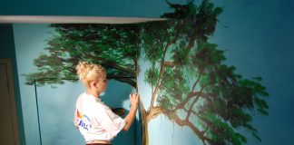 Local artist Kimberly Rideout painting a mural