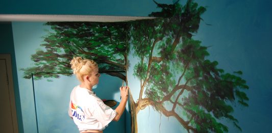 Local artist Kimberly Rideout painting a mural