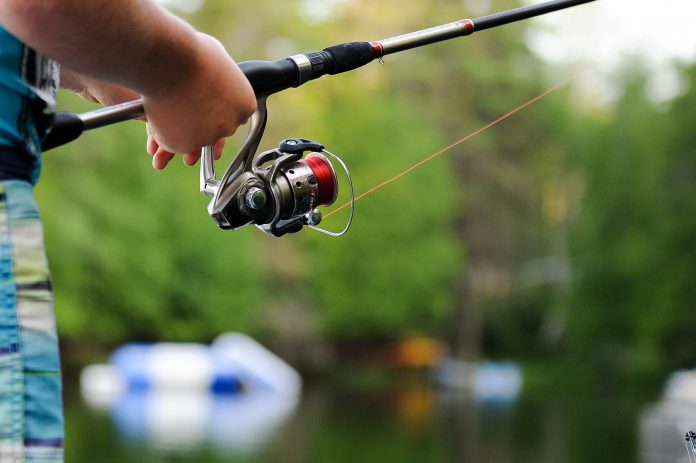A boy holding a fishing rod. Photo by Clark Young on Unsplash