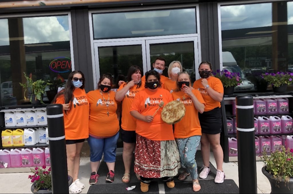 The staff at Wolf Energy Fuels wearing the t-shirts they sold to help raise $50,000 for the Save the Evidence campaign