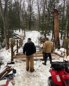 Members of the Muskoka Sno-Bombers replacing bridge deck boards