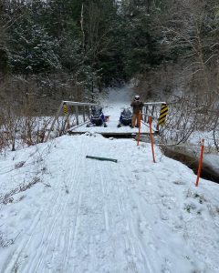The Muskoka Sno-Bombers assess erosion leading up to a bridge in Bracebridge