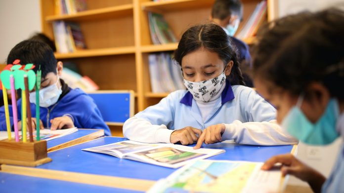 Children wear masks during a return to in-person learning at schools.