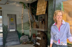 Artist Kimberly Rideout with her mural at Macaulay Tree House