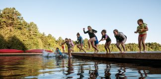 Campers jump into the lake at Camp Huronda