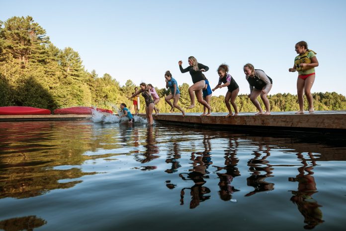 Campers jump into the lake at Camp Huronda