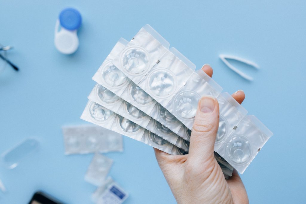 A person holding blister packs of contact lenses