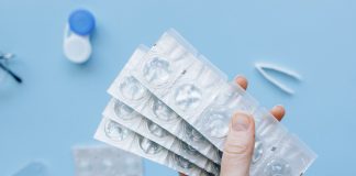 A person holding blister packs of contact lenses
