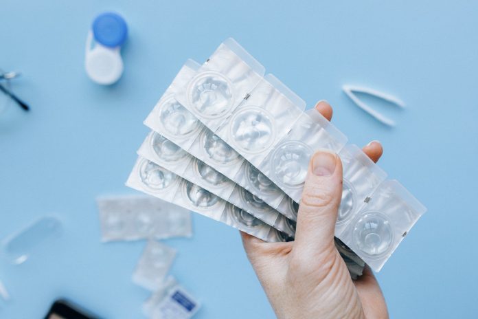 A person holding blister packs of contact lenses