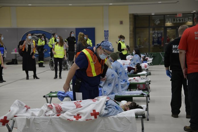 Photo 2 Mock Code Green-2 Dr. Derek Benjamin, Chief of Medicine, who volunteered to participate in the exercise is seen caring for a “patient” during the exercise