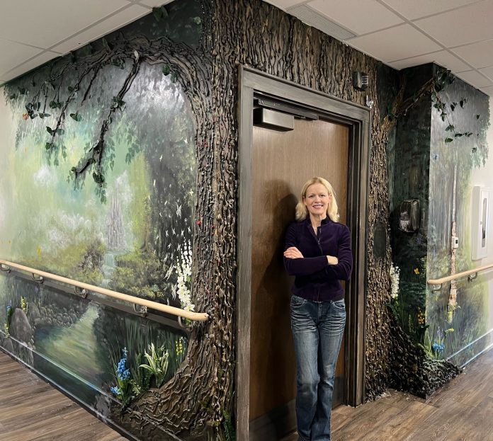 Artist Kimberly Rideout with her second mural at Andy's House