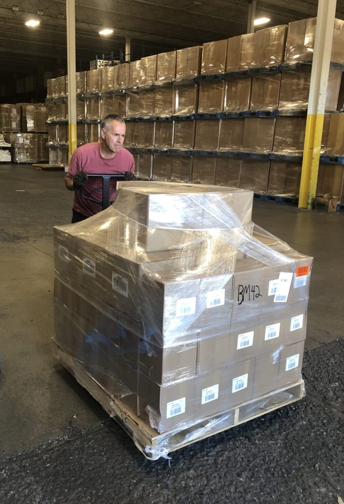 Volunteer Mike Elchyshyn helping load the skids of donations for the Shoebox Raiser on the truck at Cavalier Logistics in Bolton.